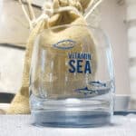 Frisches Wasser im Glas mit Meeresmotiven und Vitamin Sea Schriftzug, gesundes Trinkwasser, nachhalt.
