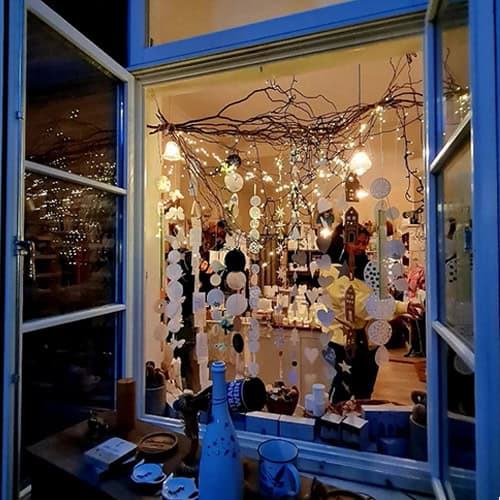 Hochwertige Weihnachtsdekoration im Schaufenster mit Lichterketten und festlicher Atmosphäre.