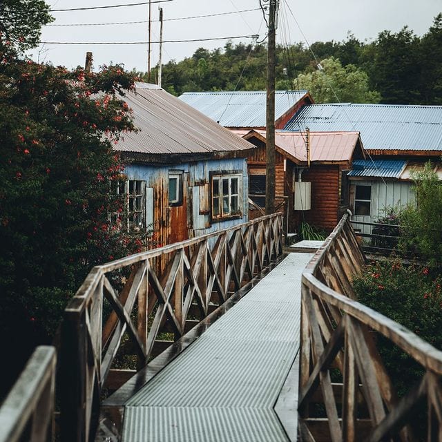 Rustikale Häuser in einem ländlichen Dorf mit Holzbrücke.