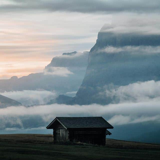 Kleine Hütte inmitten von Bergen und Nebel, Naturidyll.