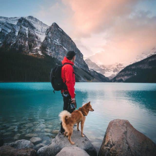 Mann mit Hund am Bergsee in den Bergen, Natur, Wandern, Outdoor-Aktivitäten.