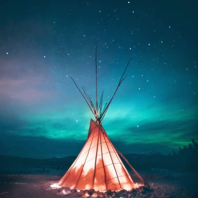 Indianerzelt unter Nordlichtern am nächtlichen Himmel.