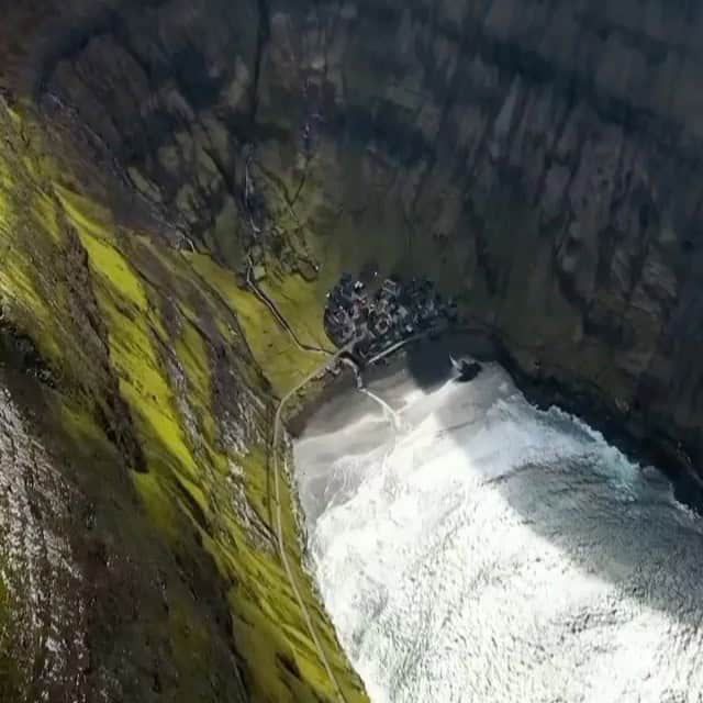 Felsiger Wasserfall inmitten von grünen Klippen, Blick von oben auf die Natur.