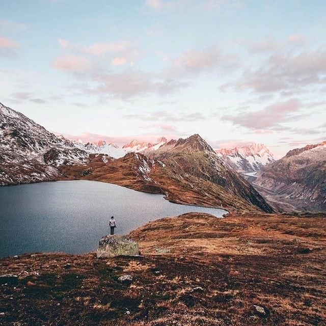Alpenbergsee mit Bergpanorama und Sonnenaufgang, ruhige Naturkulisse.