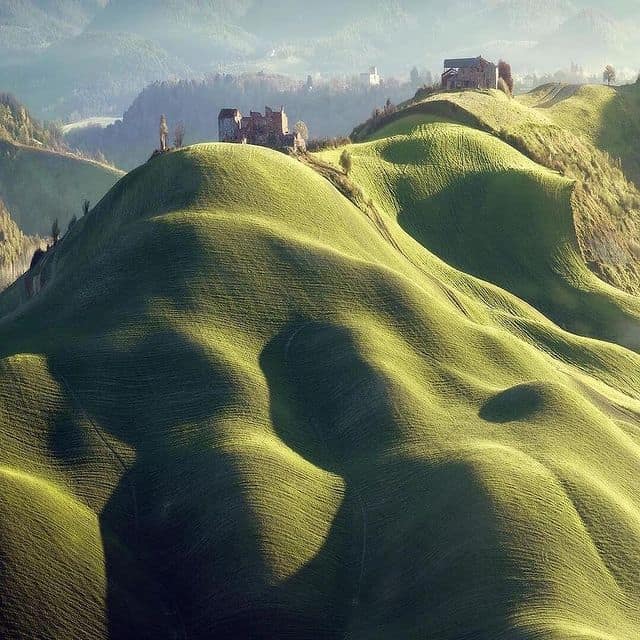 Hügel mit mittelalterlichen Burgen in der Toskana, Italien, bei Sonnenaufgang.