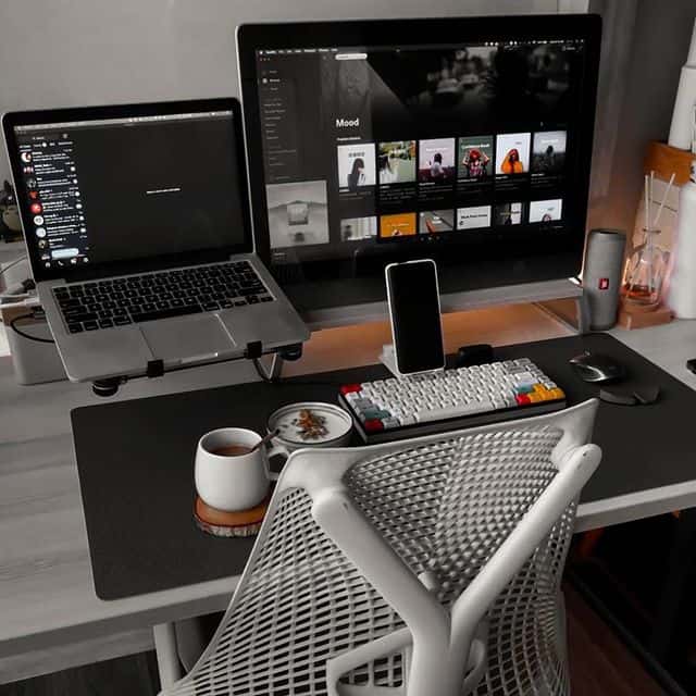Arbeitsplatz mit Laptop, Monitor, Smartphone und Kaffeetasse.