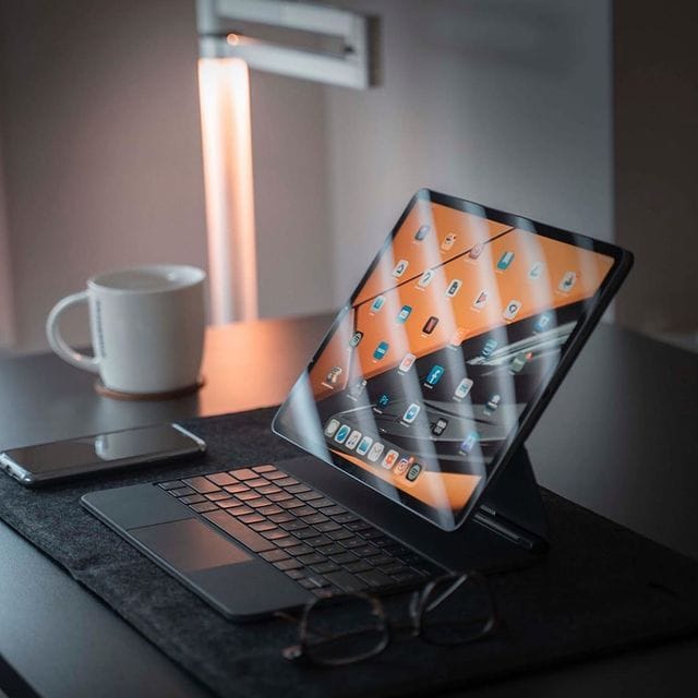 Modernes Arbeitsgerät mit Tablet, Tastatur und Smartphone auf Schreibtisch.