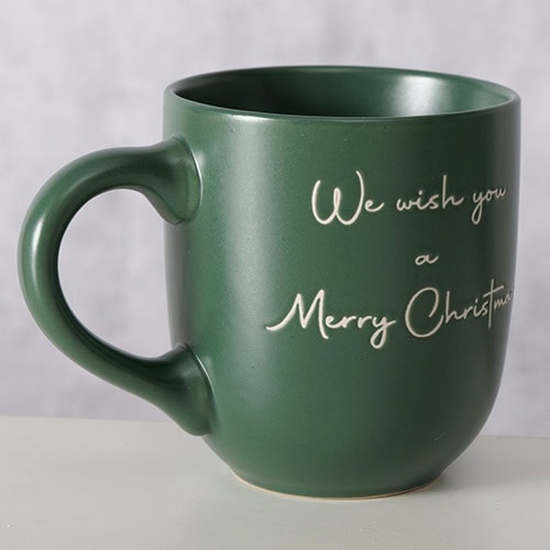 Weihnachtstasse mit Gruß "We wish you a Merry Christmas" in weißer Schrift, grüner Keramik, festlich.