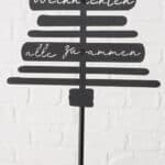 Hochwertiges Weihnachtsdeko-Schild auf weißer Ziegelwand, festliche Stimmung, winterliche Dekoration.