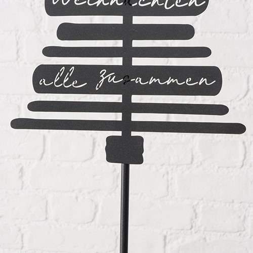 Hochwertiges Weihnachtsdeko-Schild auf weißer Ziegelwand, festliche Stimmung, winterliche Dekoration.