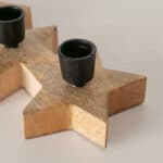 Schwarze Keramik-Tasse auf einem Holzstern-Dekor, minimalistische Tischdekoration, stilvoll und mode.