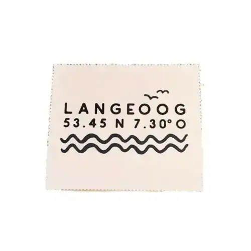Brillenputztuch mit Langeoog Koordinaten und Wellenmuster.