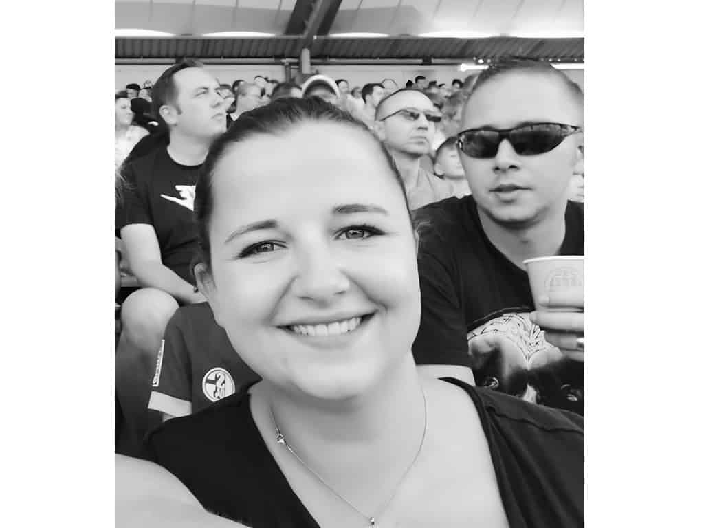 Gruppe von Menschen bei einem Event, Fokus auf lachende Frau im Vordergrund.